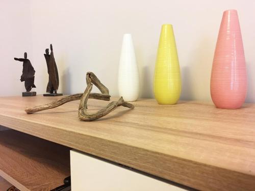 a wooden table with vases and a branch on it at L'Aparté in Nancy