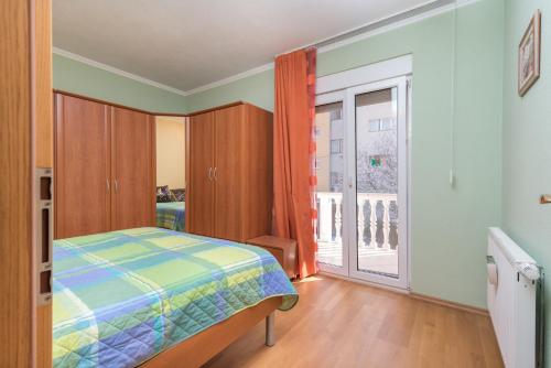 ein Schlafzimmer mit einem Bett und einem großen Fenster in der Unterkunft Vila Snjezana in Trogir