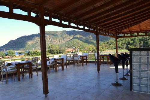 a patio with tables and chairs and a view of a mountain at Ada Adrasan Hotel in Adrasan