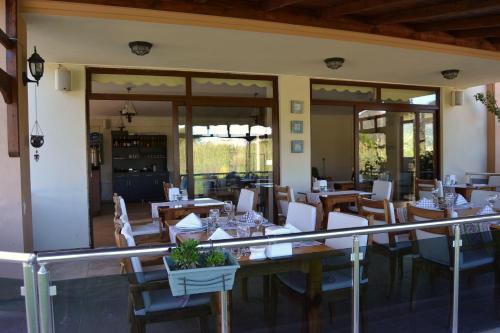 a restaurant with wooden tables and chairs and windows at Ada Adrasan Hotel in Adrasan