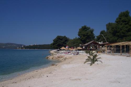 a beach with a resort and the water at Apartments Sevo in Trogir