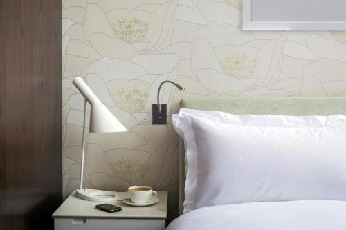 a bedroom with a white bed and a bedside table with a lamp at Hotel du Vin Exeter in Exeter