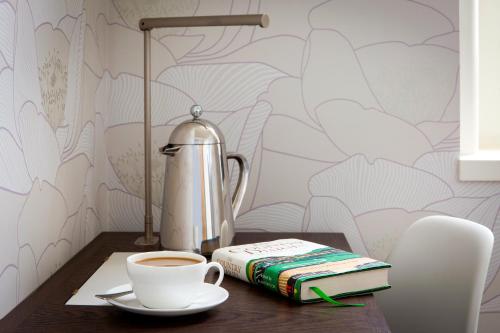 a table with a cup of coffee and a book at Hotel du Vin Exeter in Exeter