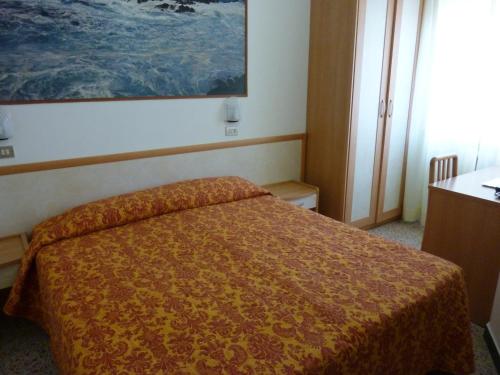 a bedroom with a bed and a painting on the wall at Hotel Apis in Rimini