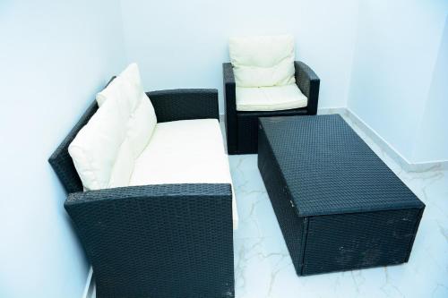 two black wicker chairs with white pillows and a table at Mama Beach Villa in Negombo