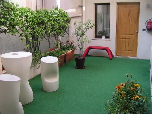 um pátio com um piso verde e um banco vermelho em Albergo Verdi em Pádua