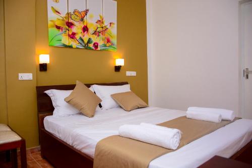 a bedroom with a bed with two pillows on it at Mama Beach Villa in Negombo