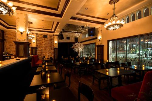 a restaurant with tables and chairs and windows at Hollywood Historic Hotel in Los Angeles