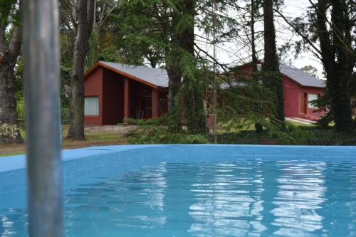 a house with a pool in front of a house at Cabaña El Tigre in Tandil