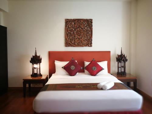a bedroom with a large bed with red pillows at Hua Hin Blue Lagoon in Cha Am