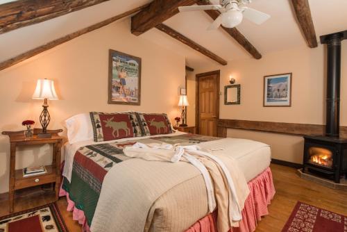 a bedroom with a bed and a fireplace at West Hill House B&B in Mad River Valley in Warren