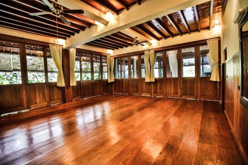 an empty living room with wooden floors and windows at Bliss Ubud Spa Resort in Ubud