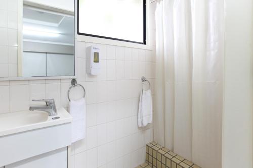 a white bathroom with a sink and a mirror at Tandara Hotel Motel in Sarina