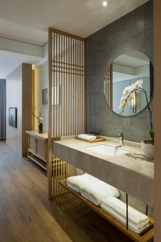 a bathroom with a sink and a mirror at The Hidden House Cheng Du Du Fu Thatched Cottàge Branch in Chengdu
