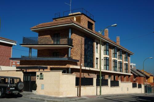 a large brick building with a balcony on top of it at Hostal Los Coronales in Madrid