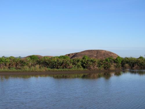 a large body of water with hills in the background at The Long Hostel in Arugam Bay