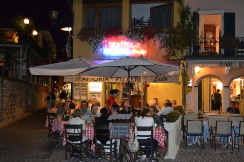 a group of people sitting at an outdoor restaurant at night at Casa Lady in Garda