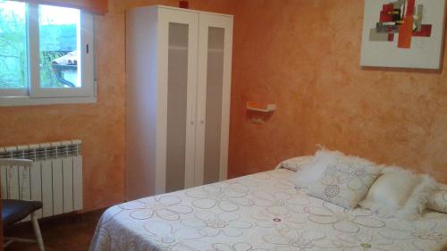 a bedroom with a white bed and white walls at Hostal A La Sombra Del Laurel in Navarrete