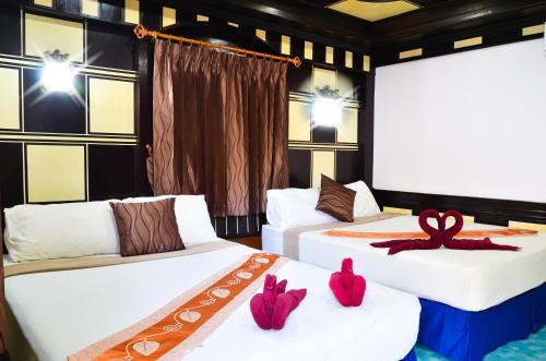 two beds in a room with red decorations on them at Nature Beach Resort, Koh Lanta in Ko Lanta