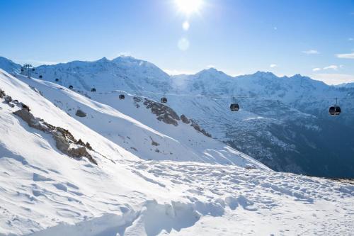 a ski lift going down a snow covered mountain at ROBINSON ALPENROSE Zürs in Zürs am Arlberg