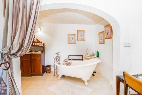 a bathroom with a white tub and a sink at Dar tal-Kaptan Boutique Maison in Għasri