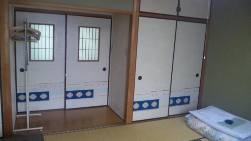 Habitación con 2 puertas correderas de cristal y 1 cama en Mizuhokan, en Ise