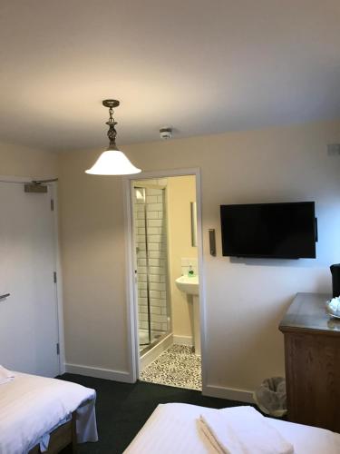 a room with a bed and a flat screen tv at The Dorrington in Halstead