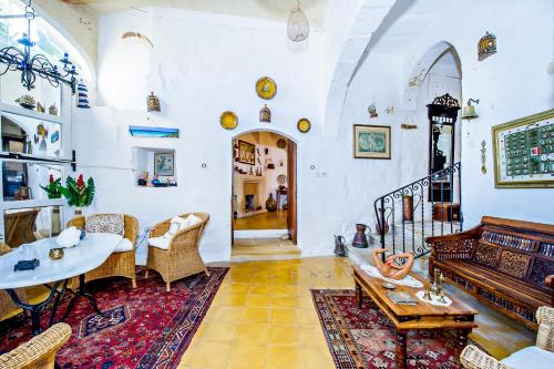 a living room with a table and some chairs at Dar tal-Kaptan Boutique Maison in Għasri