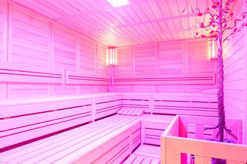 a sauna with white walls and a tree in it at Aribo Hotel in Erbendorf