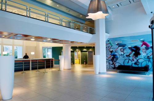 a lobby with a large mural of cyclists on the wall at Sport Club by Isrotel Collection in Eilat