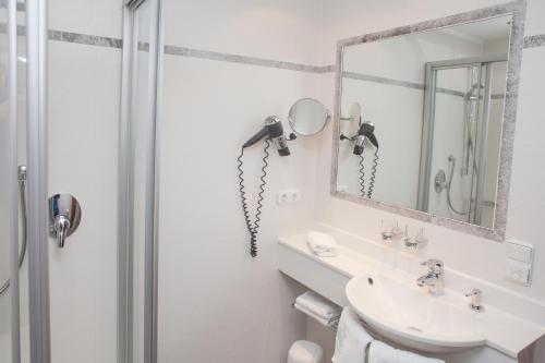 a bathroom with a shower and a sink and a mirror at Gröbl-Alm in Mittenwald