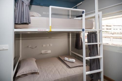 a bunk bed in a small room with a bunk bed in it at The Moon Hostel Huahin in Hua Hin