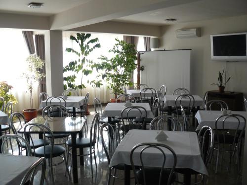 a dining room with tables and chairs and a whiteboard at Euro House Hotel in Baia Mare