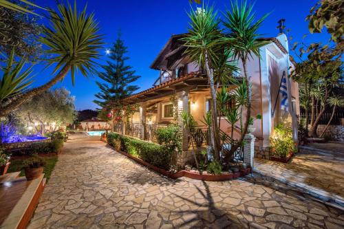 ein Haus mit Palmen vor einer Straße in der Unterkunft Villa Elea in Lithakia