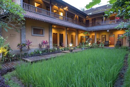 an exterior view of a house with a grass yard at Bliss Ubud Spa Resort in Ubud