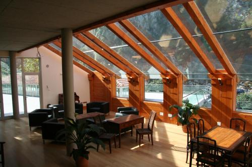 a room with tables and chairs and windows at Hotel Balneario La Hermida in La Hermida