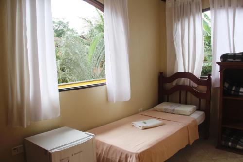 a bedroom with two twin beds and a window at Pousada da Rose Paraty in Paraty