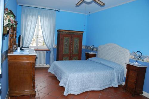 a bedroom with a bed and a blue wall at Da Cristina in Monsampolo del Tronto