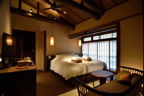 a bedroom with a bed and a desk and a television at Muromachi Yutone Kyokoyado in Kyoto