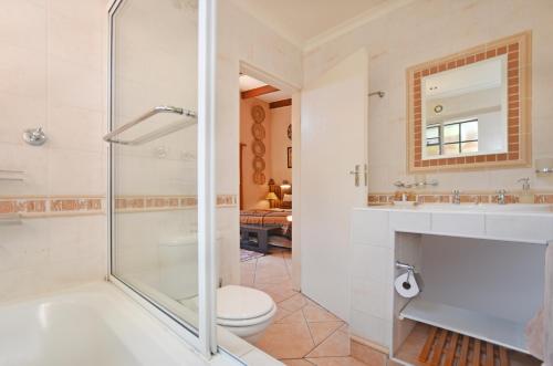 a bathroom with a shower and a toilet and a sink at Cherry Tree Cottage B&B Linden in Johannesburg