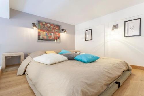 une chambre avec un grand lit avec des oreillers bleus dans l'établissement Appart Touriste, à Lyon