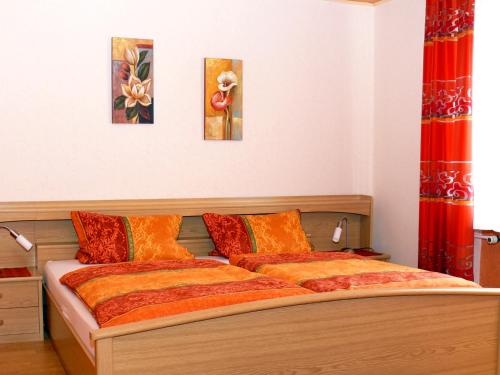 クレフにあるFerienweingut Rainer Beitzelの壁に絵画2点が飾られたベッドルームのベッド1台