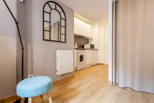 un salon avec un tabouret bleu et une cuisine dans l'établissement Appart Touriste, à Lyon