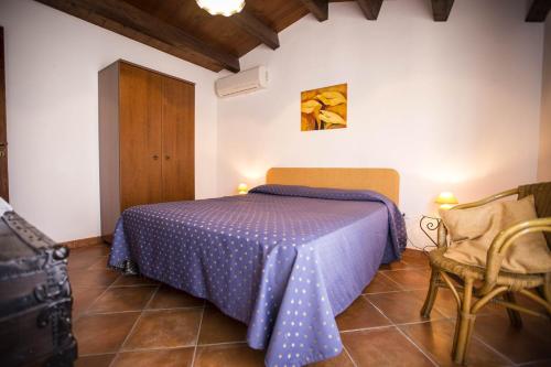 a bedroom with a blue bed and a chair at Appartamento Le Terrazze in Castellammare del Golfo