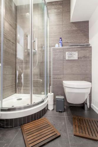 La salle de bains est pourvue d'une douche, de toilettes et d'une baignoire. dans l'établissement Appart Touriste, à Lyon