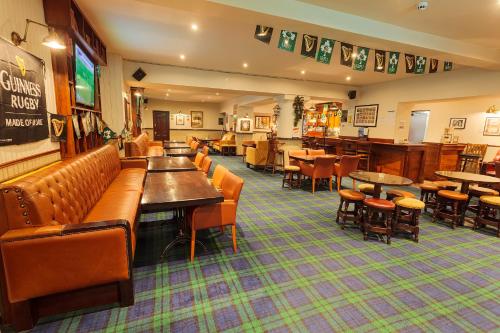 a restaurant with couches and tables and chairs at Chester Beatty Inn in Ashford