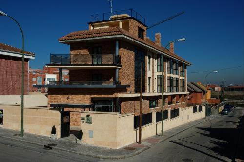 a brick building with a clock on the side of it at Hostal Los Coronales in Madrid
