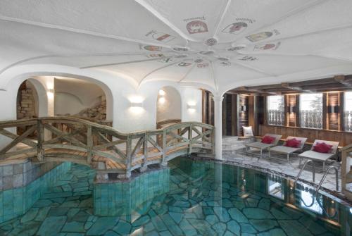 a house with a swimming pool with a ceiling at Hotel La Perla: The Leading Hotels of the World in Corvara in Badia