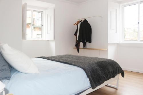 um quarto branco com uma cama e uma janela em Nooks Sintra two em Sintra