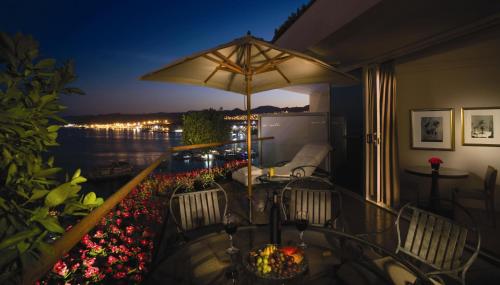 a balcony with a table and chairs and an umbrella at Royal Beach Eilat by Isrotel Exclusive in Eilat
